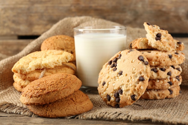 Biscotti e bicchiere di latte saporiti su fondo di legno rustico