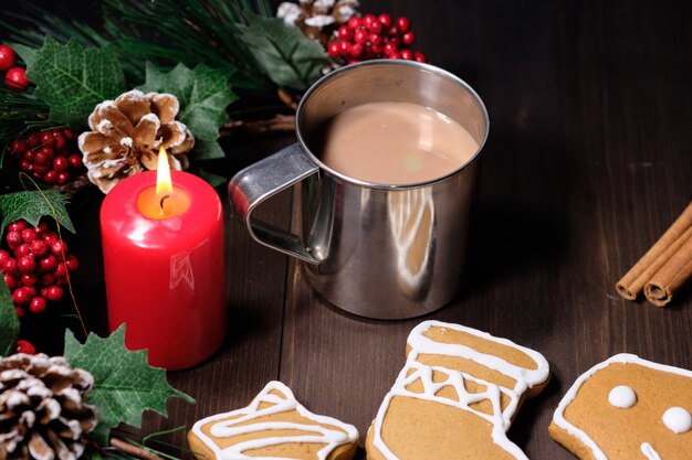 Biscotti e caffè di mandorla con latte nella tazza del ferro su marrone