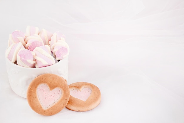 Biscotti e dolci su sfondo bianco Cuore rosa lecca-lecca e amore Dolci l ai denti e ai denti