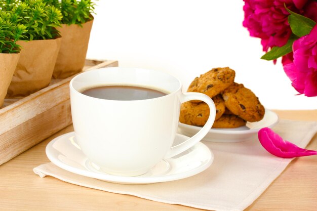 Biscotti e fiori della tazza di caffè sulla tavola in caffè