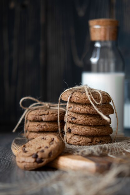 Biscotti e latte di pepita di cioccolato sulla tavola di legno