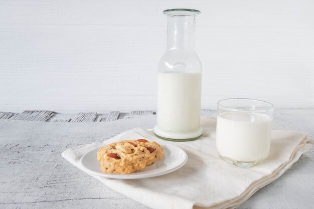 Biscotti e latte su fondo di legno bianco