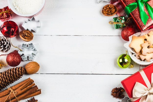 Biscotti e regali di Natale su fondo di legno bianco.