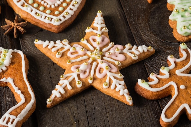 Biscotti e spezie fatti in casa di pan di zenzero di Natale sulla tavola di legno