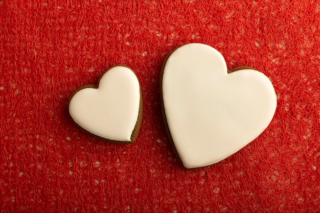 Biscotti fatti in casa a forma di cuore con zucchero a velo bianco su sfondo rosso Festa della mamma Festa della donna San Valentino