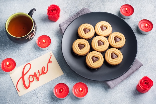 Biscotti fatti in casa a forma di cuori sul piatto, sfondo grigio. Concetto di San Valentino. copia spazio.