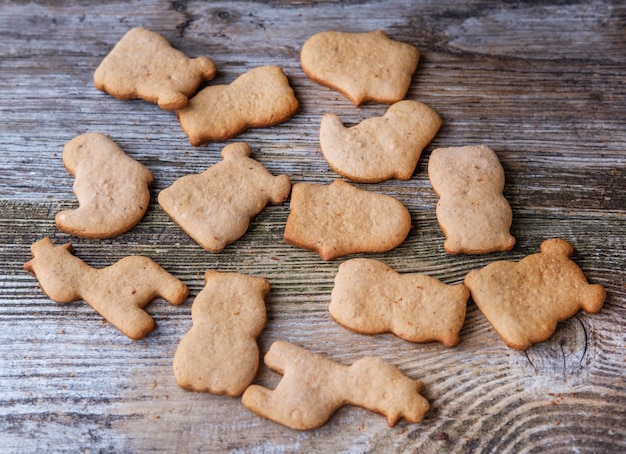 Biscotti fatti in casa allo zenzero a forma di animali sulla vecchia tavola di legno