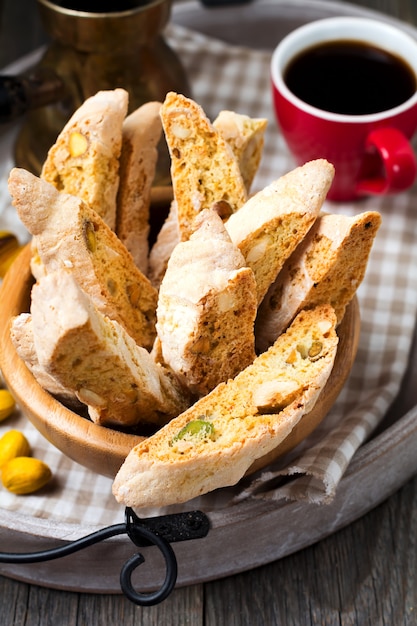 Biscotti fatti in casa con noci e una tazza di caffè sullo sfondo di tavolo in legno vecchio.