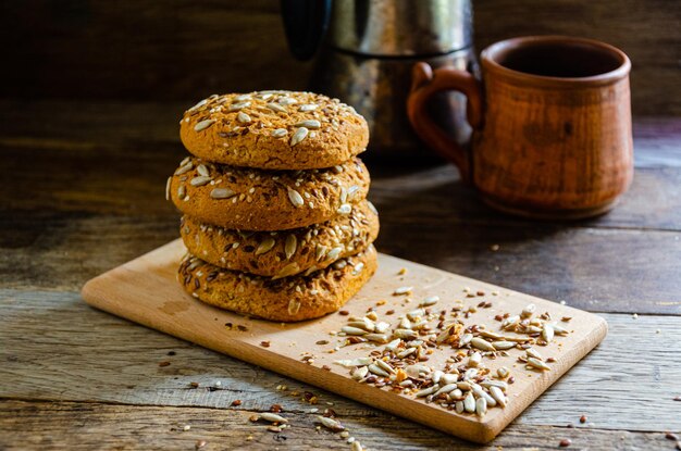 Biscotti fatti in casa di farina d'avena con grani su una tavola di legno, sul tavolo della cucina e caffè fatto in casa