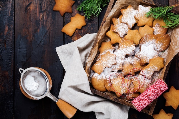 Biscotti fatti in casa di Pan di zenzero a forma di stella di Natale Capodanno in una scatola di legno sulla superficie vintage in legno vecchio