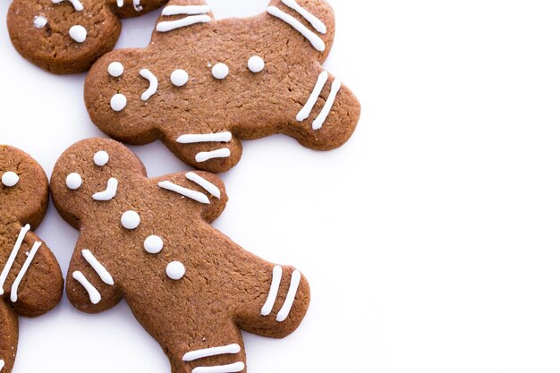 Biscotti fatti in casa di panpepato decorati con glassa bianca su sfondo bianco.