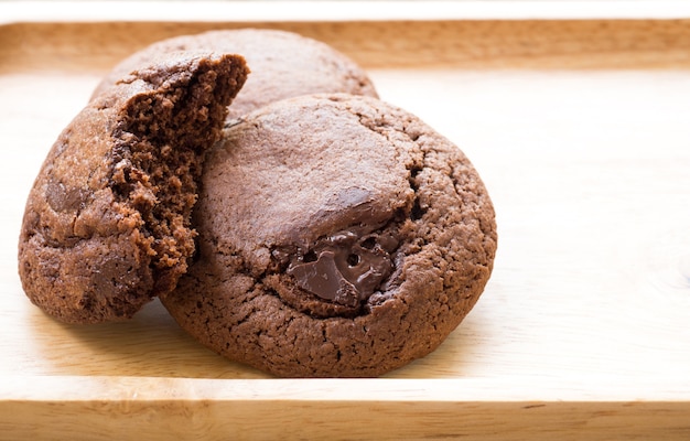 Biscotti fatti in casa morbidi biscotti al cioccolato fondente disposti su un piatto di legno.