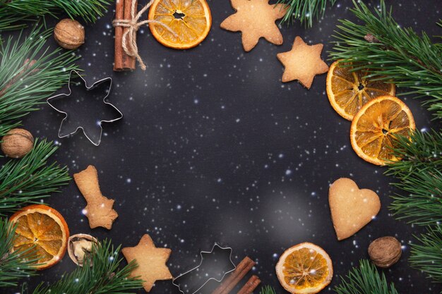Biscotti freschi fatti in casa Rami di abete Fette essiccate di arancio Tagliabiscotti Concetto di Natale