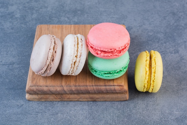 Biscotti maccheroni di diversi colori su una superficie grigio scuro