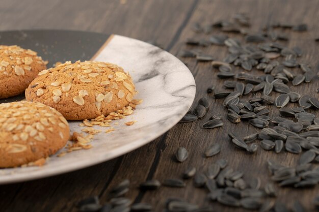 Biscotti multicereali con semi di girasole neri posti sulla tavola di legno.