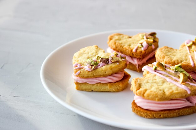 Biscotti natalizi a forma di cuore, con crema di ricotta e pistacchi