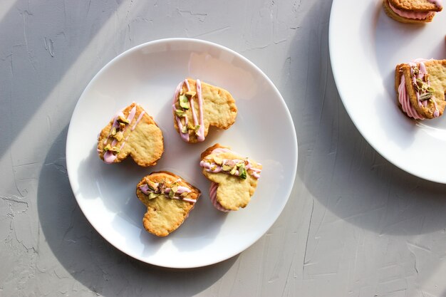 Biscotti natalizi a forma di cuore, con crema di ricotta e pistacchi