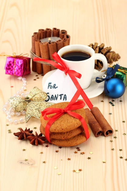Biscotti per Babbo Natale: immagine concettuale di biscotti allo zenzero, latte e decorazioni natalizie su sfondo chiaro