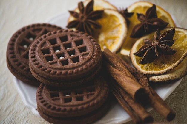 Biscotti rotondi al cioccolato con uno strato e ripieno su un piatto decorato con cannella