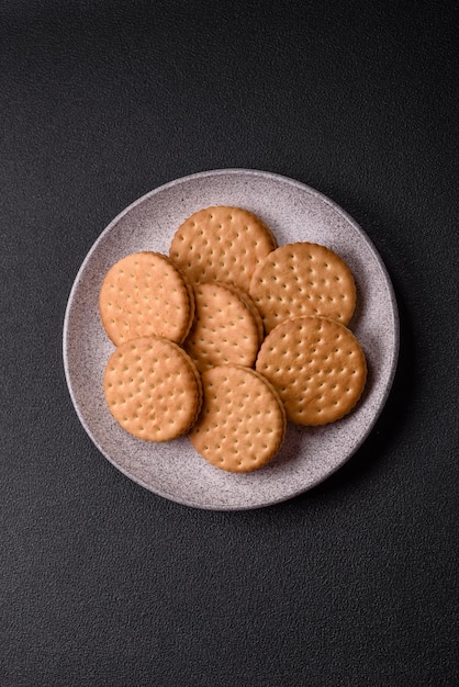 Biscotti rotondi con crema su uno sfondo di cemento scuro