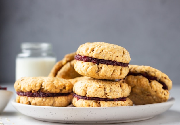 Biscotti sandwich di avena vegan con mirtilli rossi secchi e arancia. Sana colazione per bambini.