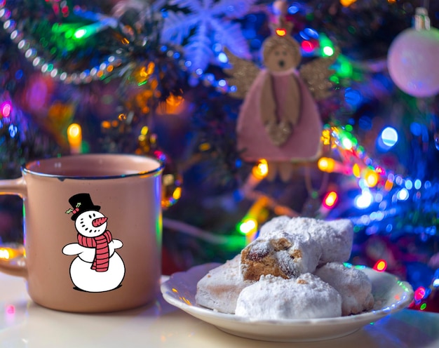 Biscotti tradizionali greci di Natale Kurabye con mandorle e zucchero a velo e una tazza di tè