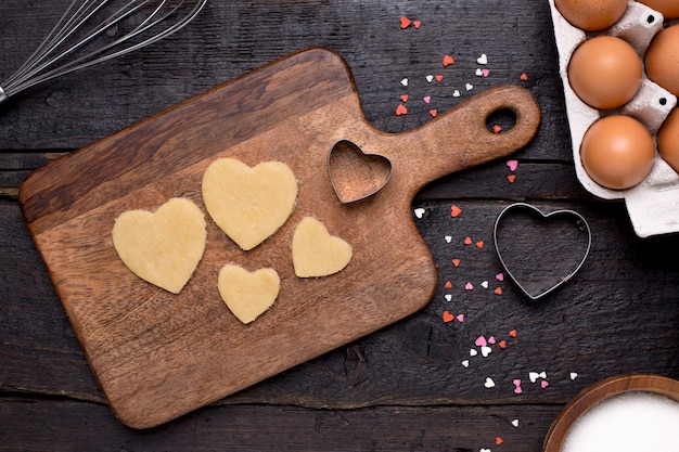 Biscotti, utensili da cucina e cuori su legno