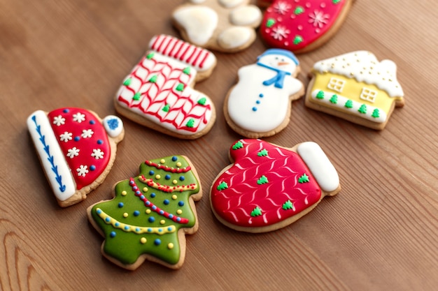 Biscotti variopinti e coni del pan di zenzero di Natale sulla tavola di legno.