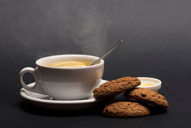 Biscotti vicino al tè su sfondo grigio scuro