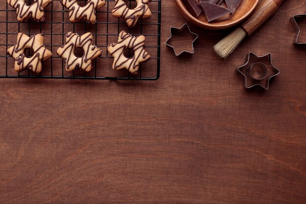 Biscotto a forma di stella fatto in casa appena cotto con il cioccolato sulla griglia sul tavolo di legno