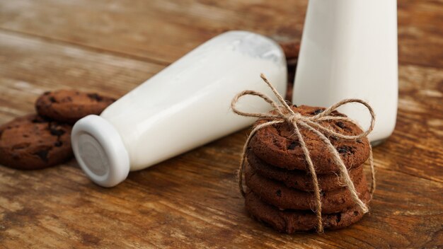 Biscotto al cioccolato con latte sulla tavola di legno. Biscotti fatti in casa. Il concetto di alimentazione naturale e sana. Prodotti da forno