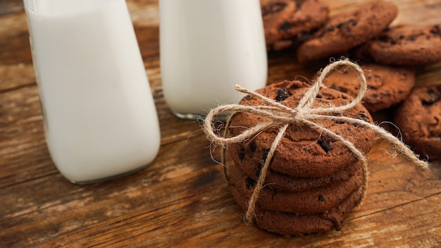 Biscotto al cioccolato con latte sulla tavola di legno. Biscotti fatti in casa. Il concetto di alimentazione naturale e sana. Prodotti da forno