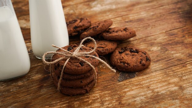 Biscotto al cioccolato con latte sulla tavola di legno. Biscotti fatti in casa. Il concetto di alimentazione naturale e sana. Prodotti da forno