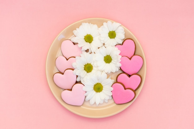 Biscotto CoGinger nel cuore di forma su fondo rosa pastello