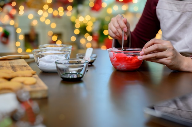 Biscotto di Natale fatto in casa per Natale e felice anno nuovo. Donna che cucina pan di zenzero con un amico e la famiglia in vacanza invernale a casa.