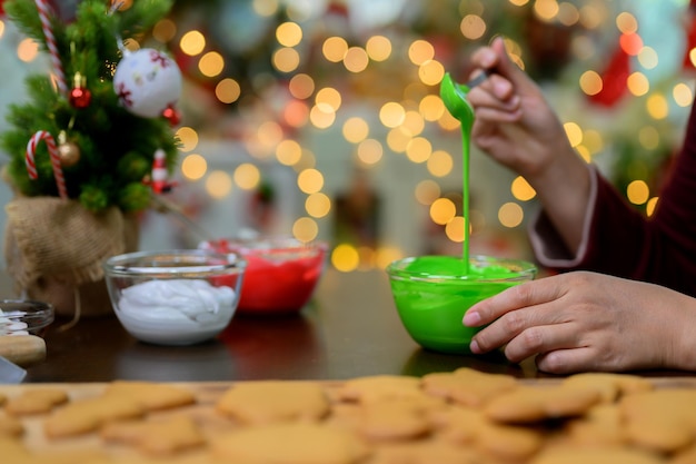 Biscotto di Natale fatto in casa per Natale e felice anno nuovo. Donna che cucina pan di zenzero con un amico e la famiglia in vacanza invernale a casa.