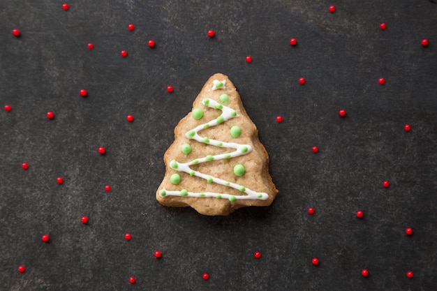 Biscotto di panpepato di Natale a forma di albero di Natale su sfondo scuro