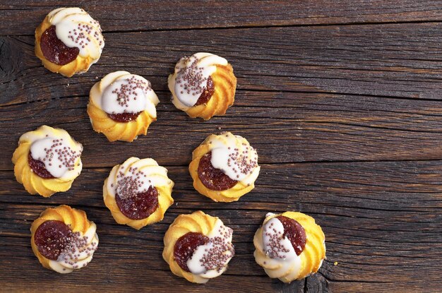 Biscotto di pasta frolla con marmellata e glassa di zucchero su fondo di legno scuro Vista dall'alto con spazio per la copia