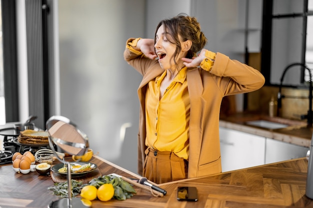 Bisnesswoman assonnata in cucina la mattina presto