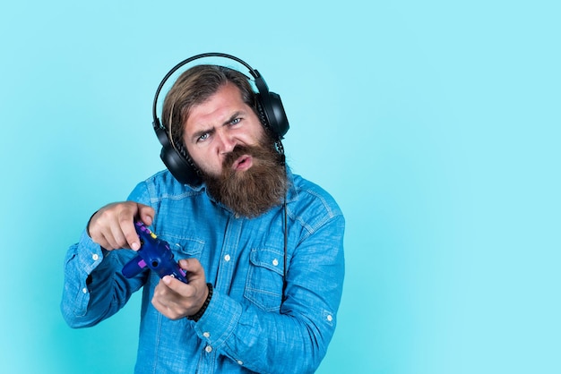 Bisogno di vincere. rilassati a casa. joystick del controller della console. giochi in cuffia. il giocatore maturo gioca ai giochi per computer. ragazzo con la barba che gioca ai videogiochi. brutale hipster caucasico con i baffi.