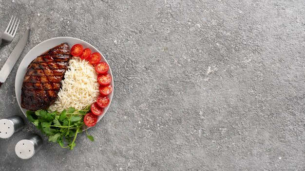 Bistecca al barbecue con riso e pomodorini serviti con coriandolo e salsa di pomodoro, piatto di un ristorante fast food che mangia fuori dallo spazio della copia