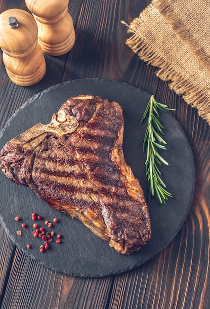 Bistecca alla fiorentina alla griglia con rosmarino fresco e peperoncino sulla tavola di pietra