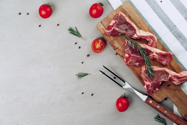 Bistecca alla fiorentina cruda sul tagliere di legno sulla fine del tavolo in legno