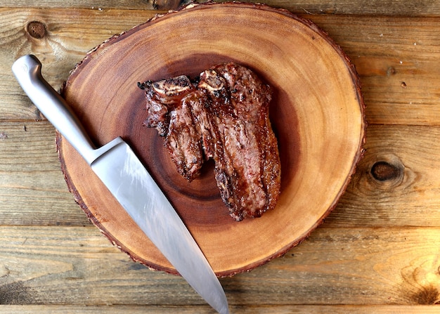 Bistecca alla griglia alla griglia con osso e due tipi di carne su fondo in legno
