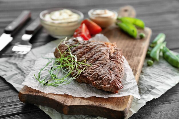 Bistecca alla griglia con salse e verdure sul tagliere