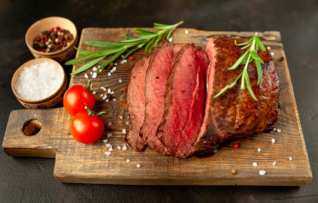 bistecca alla griglia con spezie su un tagliere, sfondo di pietra, vista dall'alto