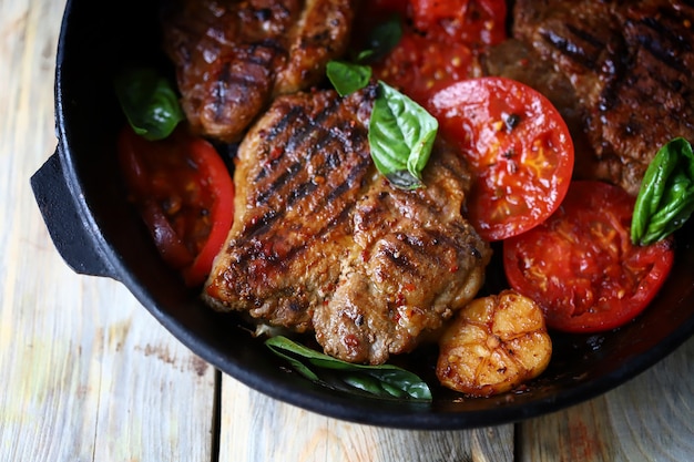 Bistecca alla griglia succosa appetitosa con verdure grigliate in padella