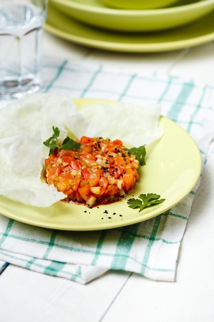 Bistecca alla tartara con insalata di verdure e patatine fritte sul piatto