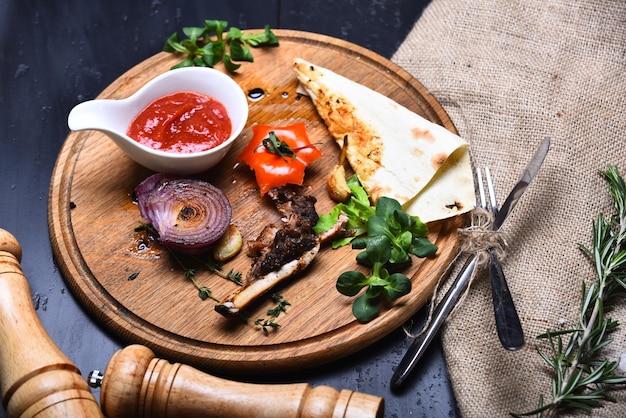 Bistecca arrosto con focaccia al pomodoro e piatto americano di cipolla