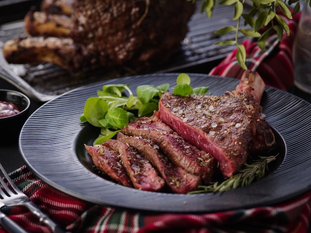 Bistecca con l'osso. Occhio costato. Bistecca di Tomahawk sulla banda nera con rosmarino. Torrefazione - Rara. Entrecote.